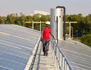 Technician on a walkway between solar panels