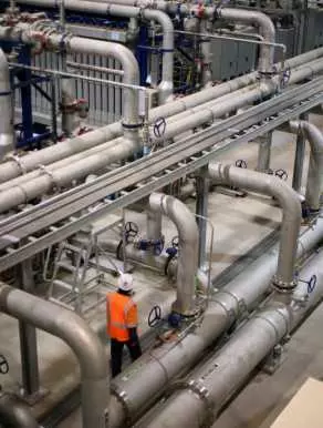 Man walking along many pipes