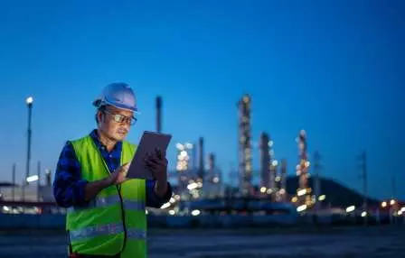 Man standing reading a tablet