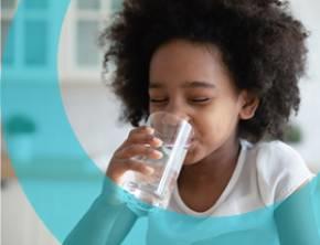 Jeune fille bouvant un verre d'eau