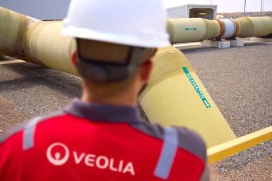 Technicien de dos regardant examinant un tuyau jaune dans une usine de dessalement