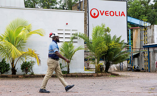 Homme marchant devant bâtiment Veolia