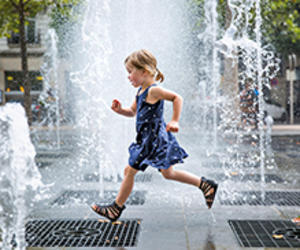 Enfant courant entre des jets d'eau
