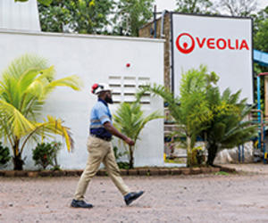 Homme marchant devant bâtiment Veolia