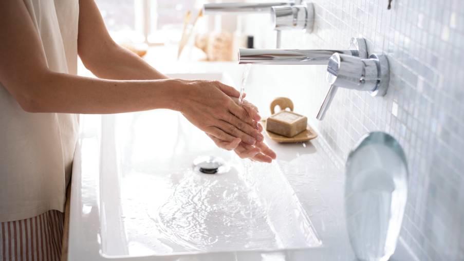 une femme se lave les mains