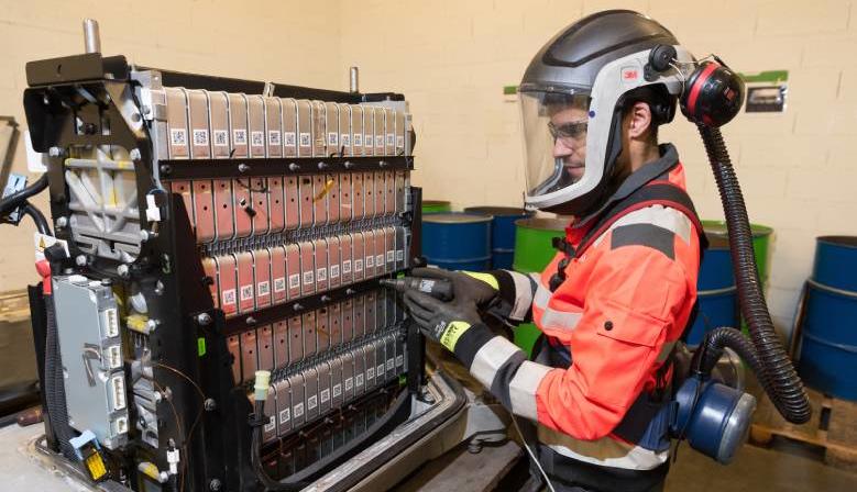 un technicien classe les batteries électriques usagées