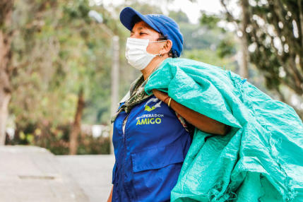 femme qui ramasse un sac de déchets