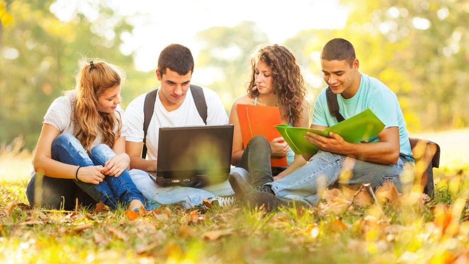 Students sitting in the grass working on ecological transformation