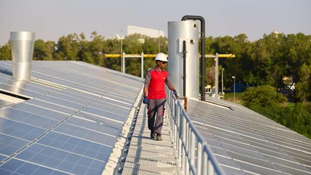 Technician on a walkway between solar panels